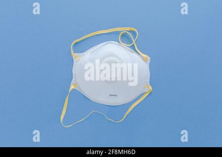 Blanc FFP2, N95 filtre pour masque de protection respiratoire industriel masque de sécurité isolé sur fond bleu. Protection contre les bactérias et les virus, y compris Covid-19 Banque D'Images