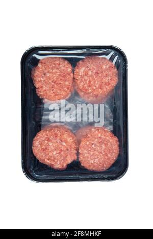 Boulettes de viande de bœuf cru dans un plateau de plastick noir isolé sur fond blanc. Banque D'Images