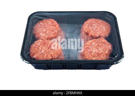 Boulettes de viande de bœuf cru dans un plateau de plastick noir isolé sur fond blanc. Banque D'Images