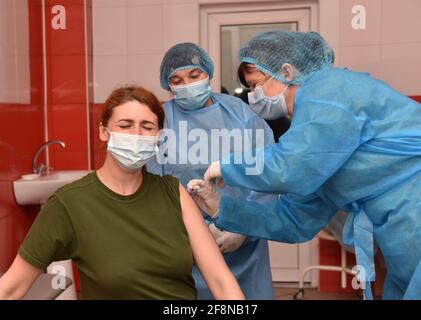 Lviv, Ukraine. 14 avril 2021. Un agent de santé vaccine une dose du vaccin AstraZeneca auprès du servicewoman de la Garde nationale d'Ukraine.la vaccination de la population contre le coronavirus se poursuit en Ukraine. Aujourd'hui, les travailleurs médicaux, les personnes d'âge respectable, les travailleurs sociaux, les militaires, ceux qui fournissent le travail de la ville, les personnalités publiques sont vaccinés. En avril 14, 403,556 vaccins ont été administrés contre le coronavirus en Ukraine. Crédit : SOPA Images Limited/Alamy Live News Banque D'Images