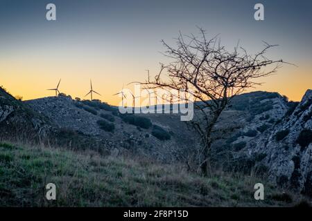 Paysage de moulins à vent sur les collines rocheuses pendant le coucher de soleil dedans le soir Banque D'Images