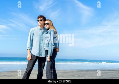 Jeune couple portant des lunettes de soleil à la plage Banque D'Images