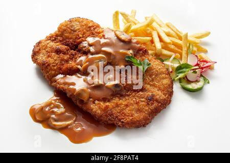 Gros plan sur le schnitzel traditionnel de veau plat allemand avec le chasseur aromatique Sauce aux champagnes servis avec des frites et de la salade Banque D'Images