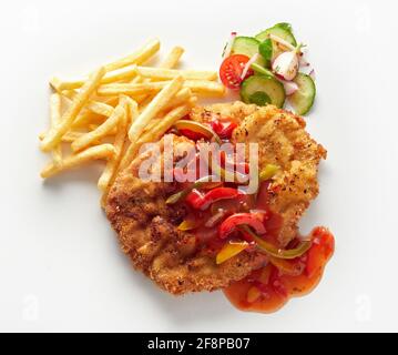 Vue de dessus de délicieux schnitzel de viande garni de gitan traditionnel sauce servie avec des pommes de terre frites et de la salade de légumes frais arrière-plan blanc Banque D'Images