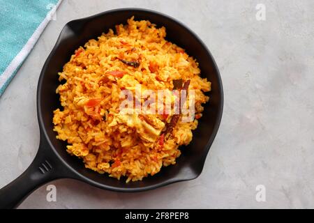 Riz aux tomates avec œufs. Incorporer le riz frit dans la sauce tomate épicée, mélangé avec des œufs et des épices. Servi dans une poêle à repasser. Banque D'Images