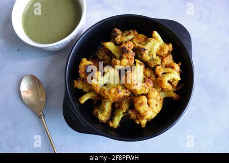 Gobi ou Gobhi Tandoori. Le chou-fleur rôti au masala est un plat indien végétarien populaire servi avec du chutney à la menthe et à la coriandre. Banque D'Images