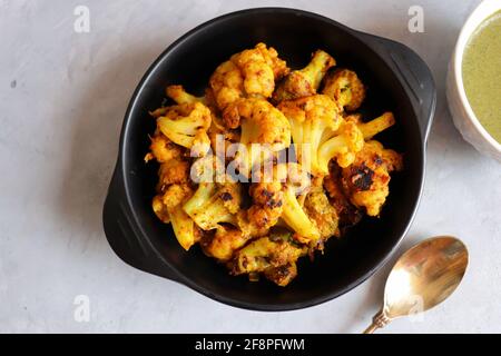 Gobi ou Gobhi Tandoori. Le chou-fleur rôti au masala est un plat indien végétarien populaire servi avec du chutney à la menthe et à la coriandre. Banque D'Images