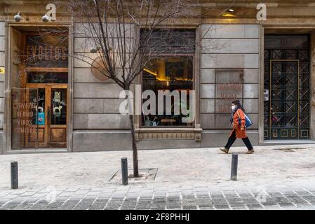 Madrid, Espagne - 31 janvier 2021: Une femme marchant à côté de vide Tapas Bar dans le centre historique de Madrid pendant les restrictions pour la pandémie de coronavirus Banque D'Images