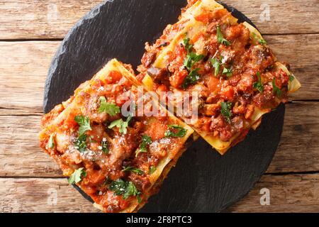 Pâtes lasagne viande, foie de poulet et légumes vincisgrassi recette gros plan sur un tableau d'ardoise sur la table. Vue horizontale du dessus Banque D'Images