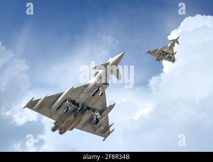 Deux avions Eurofighter du typhon survolant le centre-ville avec des missiles sur le chemin de la mission. Avions de chasse modernes en formation avec une incroyable force aérienne Banque D'Images