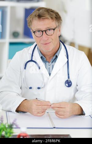 homme médecin dans les lunettes regarde l'appareil photo Banque D'Images