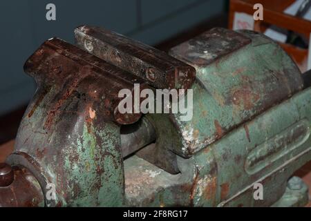 ancien étau en métal rouillé sur un établi dans l'atelier Banque D'Images