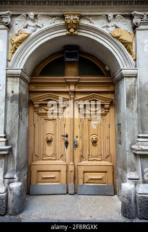 Anciennes portes doubles en bois peint avec des défonces à lion dans un Porte voûtée Banque D'Images