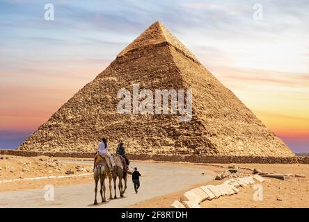 Touristes en chameaux avec bédouin près de la Pyramide de Chephren, Egypte Banque D'Images