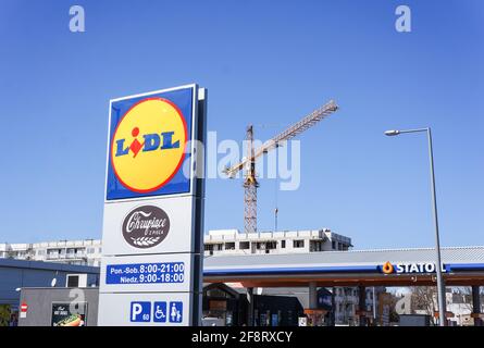POZNAN, POLOGNE - 06 avril 2016 : panneau de supermarché Lidl avec heures d'ouverture près d'une station de remplissage Statoil Banque D'Images