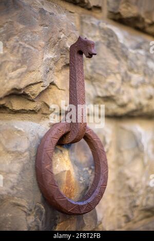 Anneau d'attelage de cheval rouillé sur un mur de pierre ancienne Banque D'Images