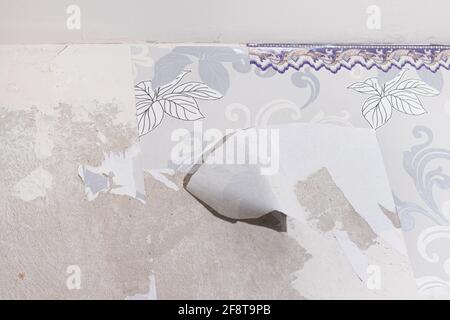 Le mur après avoir retiré le papier peint - traces de plâtre sur la surface en béton. Rénovation dans l'appartement avec des traces de papier peint ancien. Banque D'Images