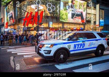 Voiture de police devant le magasin H&M la nuit, Times Square, New York City, États-Unis d'Amérique. Véhicule de patrouille NYPD à Times Square. Manhattan Banque D'Images