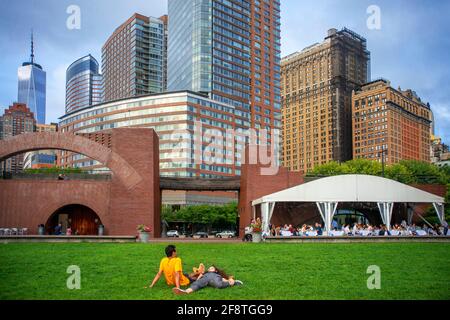 Personnes se détendant dans le jardin urbain de Battery Park, Lower Manhattan, New York, New York, Etats-Unis, Amérique du Nord. À l'arrière Gigino au restaurant du parc Wagner Banque D'Images