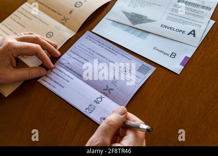 East Lothian, Écosse, Royaume-Uni, 15 avril 2021. Les bulletins postaux arrivent pour les élections écossaises : les résidents du comté peuvent voter pour la MSP du Lothian est et la région du sud de l'Écosse. Les candidats pour les premiers sont Euan Davidson (Démocrates libéraux écossais), Craig Hoy (conservateurs écossais et unionistes), Paul McLennan (SNP) et Martin Whitfield (Parti travailliste écossais et ancien député qui a perdu en 2019 à Kenny MacAskill, qui est en lice pour Alba). La liste régionale comprend 16 parties. Un homme choisit pour qui voter sur le bulletin de vote Banque D'Images