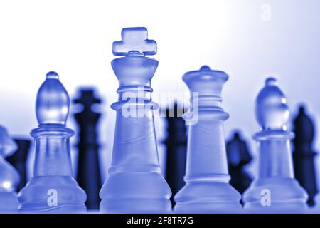 Allemagne. 11 avril 2021. Pièces d'échecs symboliques d'un jeu d'échecs en verre avec un fond neutre. Détail de quelques chiffres blancs avec une lumière bleue d'humeur du point de vue d'une petite grenouille. Il y a des figures noires en arrière-plan. | utilisation dans le monde crédit: dpa/Alay Live News Banque D'Images