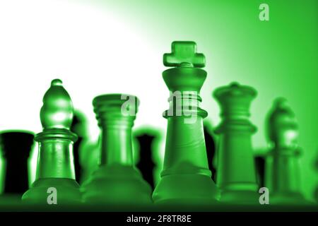 Allemagne. 11 avril 2021. Pièces d'échecs symboliques d'un jeu d'échecs en verre avec un fond neutre. Détail de quelques chiffres blancs avec une lumière verte d'humeur d'une légère grenouille. Il y a des figures noires en arrière-plan. | utilisation dans le monde crédit: dpa/Alay Live News Banque D'Images