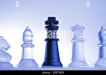 Allemagne. 11 avril 2021. Pièces d'échecs symboliques d'un jeu d'échecs en verre avec un fond neutre. Détail de quelques chiffres blancs et le roi noir avec une lumière bleue d'humeur d'une légère grenouille. | utilisation dans le monde crédit: dpa/Alay Live News Banque D'Images