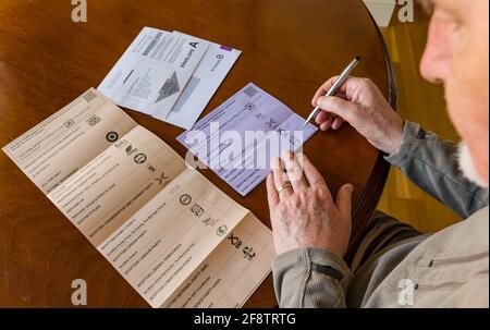 East Lothian, Écosse, Royaume-Uni, 15 avril 2021. Les bulletins postaux arrivent pour les élections écossaises : les résidents du comté peuvent voter pour la MSP du Lothian est et la région du sud de l'Écosse. Les candidats pour les premiers sont Euan Davidson (Démocrates libéraux écossais), Craig Hoy (conservateurs écossais et unionistes), Paul McLennan (SNP) et Martin Whitfield (Parti travailliste écossais et ancien député qui a perdu en 2019 à Kenny MacAskill, qui est en lice pour Alba). La liste régionale comprend 16 parties. Un homme considère pour qui voter sur le bulletin de vote Banque D'Images