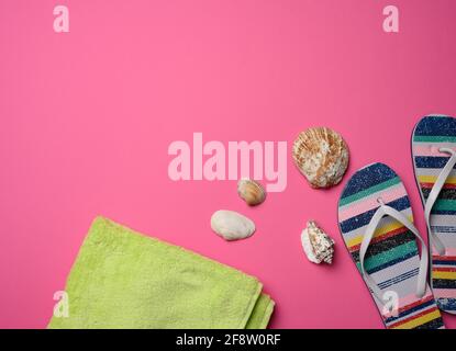 pantoufles multicolores pour femmes et seashell sur fond rose, vue du dessus