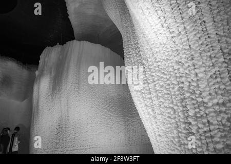 Une fabuleuse grotte de glace artificielle, les murs sont couverts de neige et illuminés. Glace congelée et froide à l'intérieur Banque D'Images