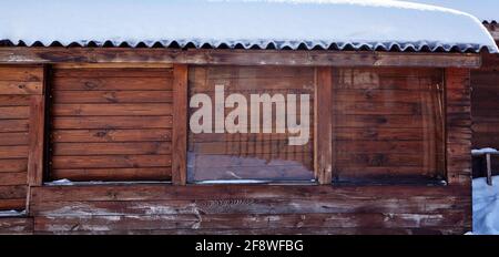 Un toit enneigé d'une maison en bois. Immeuble en bois avec beaucoup de neige sur le toit Banque D'Images