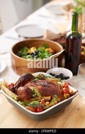 Gros plan de poulet rôti avec légumes dans le plat sur le table servie pour le dîner Banque D'Images