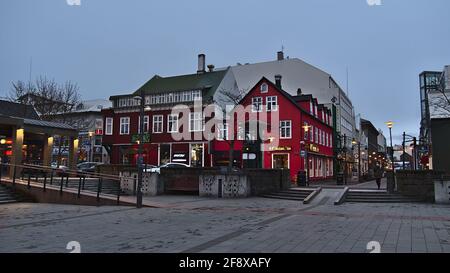 Vue sur la place Ingólfstorg dans le centre de Reykjavik, capitale de l'Islande, le soir avec des restaurants et des boutiques. Banque D'Images