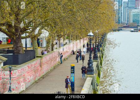 Londres, Royaume-Uni. 13 avril 2021. Personnes visitant le mur commémoratif national de Covid. Environ 150,000 coeurs ont été peints par des bénévoles et des membres du public, un pour chaque victime Covid-19 au Royaume-Uni à ce jour, sur le mur à l'extérieur de l'hôpital St Thomas, en face des chambres du Parlement. Banque D'Images