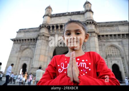 Mumbai, Maharashtra, Inde- Asie; 28 décembre 2011 - cinq ans petite mignonne fille salutation traditionnel accueil pose namaste devant la porte de l'Inde. Banque D'Images