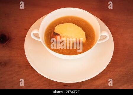 Soupe à l'oignon français dans le style Lyon – Soupe à l’Oignon Lyonnaise (ou Gratinée Lyonnaise) dans un bol blanc Banque D'Images