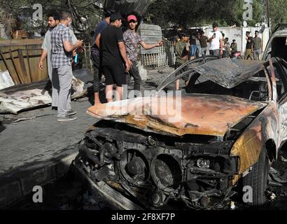 Bagdad. 15 avril 2021. La photo prise le 15 avril 2021 montre le reste d'un véhicule brûlé par l'explosion d'une voiture piégée dans la ville de Sadr, à Bagdad, en Irak. Jusqu'à cinq personnes ont été tuées et 21 autres blessées jeudi dans une explosion de voitures piégée dans une zone surpeuplée de l'est de Bagdad, a déclaré une source du ministère de l'intérieur. L'explosion s'est produite dans l'après-midi lorsqu'une voiture piégée a explosé près d'un marché dans la région d'Al-Habiyah, dans la ville de Sadr, a déclaré la source à Xinhua, sous réserve d'anonymat. Credit: Khalil Dawood/Xinhua/Alamy Live News Banque D'Images