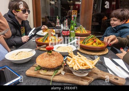 Une famille apprécie un moyen dans un restaurant pour la première fois depuis que le confinement a acheté à cause du coronavirus. Manger à l'extérieur selon les règles en vigueur. Banque D'Images