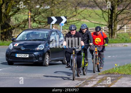 Dépassement de voitures cyclistes; dépassement d'un cycliste, dépassement de véhicules, dépassement de véhicules lents, règle 188 du Code de la route règles pour le dépassement de cyclistes sur les routes. Banque D'Images