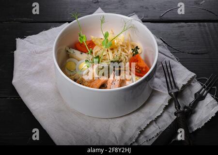 Pâtes au saumon. Cuisine méditerranéenne : pâtes, saumon cuit, tomates, câpres, œuf de caille, fromage bleu et sauce au piment vert. La cuisine méditerranéenne en un coup Banque D'Images