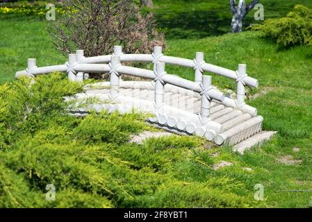 Pont en pierre blanche en plein air dans la nature, jardin japonais Banque D'Images