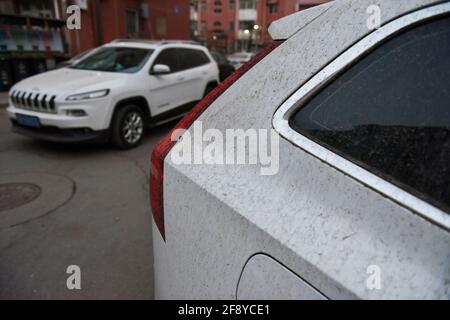 Une voiture vue garée alors qu'elle est recouverte de poussière. À Beijing, la poussière, la gale et les pluies apparaissent en même temps. La poussière mélangée à la pluie, aux piétons extérieurs et aux véhicules ont causé beaucoup de problèmes. Banque D'Images