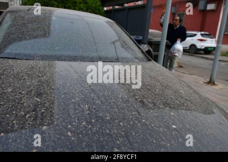 Une voiture vue garée alors qu'elle est recouverte de poussière. À Beijing, la poussière, la gale et les pluies apparaissent en même temps. La poussière mélangée à la pluie, aux piétons extérieurs et aux véhicules ont causé beaucoup de problèmes. Banque D'Images