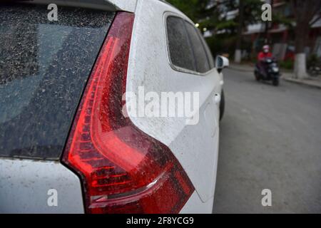 Une voiture vue garée alors qu'elle est recouverte de poussière. À Beijing, la poussière, la gale et les pluies apparaissent en même temps. La poussière mélangée à la pluie, aux piétons extérieurs et aux véhicules ont causé beaucoup de problèmes. Banque D'Images