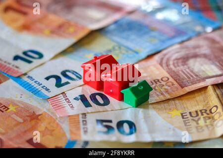 Tableau recouvert de billets en euros avec des maisons en haut. Concept d'investissement immobilier Banque D'Images