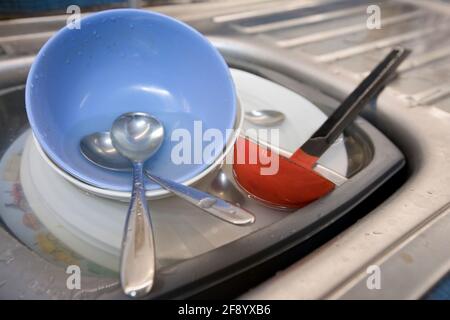 Lavage entassé dans un évier de cuisine prêt à être lavé. Banque D'Images