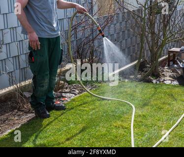 Jardinier arrosoir le gazon fraîchement posé Banque D'Images
