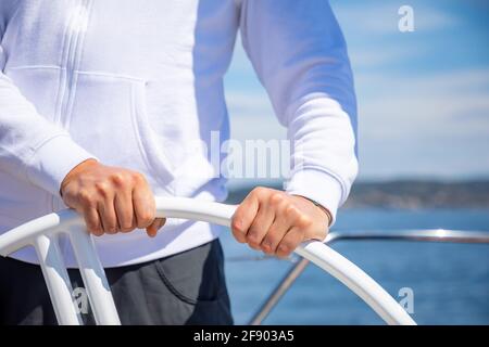 Yachtsman tenant la roue sur un voilier pendant le yachting, Croatie Banque D'Images