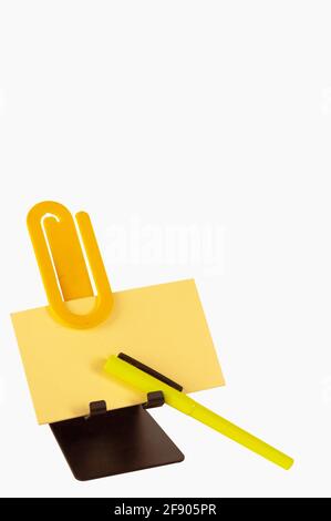 Le bloc-notes, le stylo et le clip sur le support sont des éléments dont vous avez besoin pour rédiger une liste ou un message urgent. L'espace de copie de la photo est correct. Banque D'Images