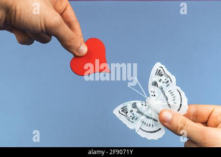 Concept de fond de charité, la main de garçon donne un coeur rouge à la nature, sauver la photo de terre Banque D'Images